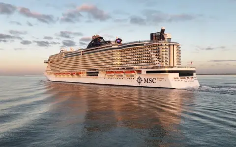 La MSC Seascape, imponente nella sua lunghezza, solca le acque calme al tramonto, riflettendosi sul mare.