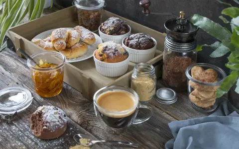 Idealny moment na fika w Szwecji: kawa, rogaliki, muffinki i ciasteczka w kształcie serc na drewnianej desce.