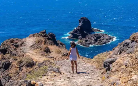 Sentiero roccioso verso il mare blu, un assaggio delle isole Canarie quali sono.