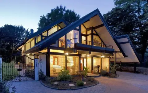 Maison moderne avec grandes fenêtres, balcons et jardin. Le prix d'une maison autonome comme celle-ci peut varier.
