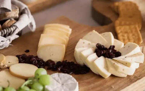 Deska serów z winogronami, suszoną żurawiną i pieczywem. Idealna na spotkanie z przyjaciółmi.