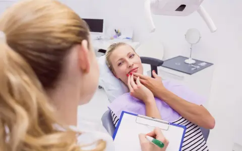 Kobieta w ciąży konsultuje z dentystką co na ból zęba w ciąży. Dentystka notuje na kartce.