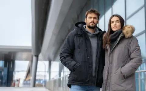 Para zimowych spacerów: on w czarnej, ona w szarej kurtce z futrzanym kapturem. Idealna jaka kurtka na zimę dla pary.