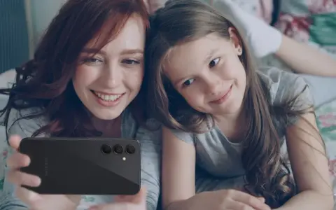 Mama i córka robią selfie telefonem. Od ilu lat można mieć telefon? Odpowiedź zależy od rodziców i dziecka.