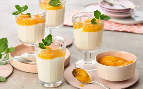 Leckeres Quarkspeise Rezept: Cremige Desserts mit Mandarinen und Minze in Gläsern serviert.