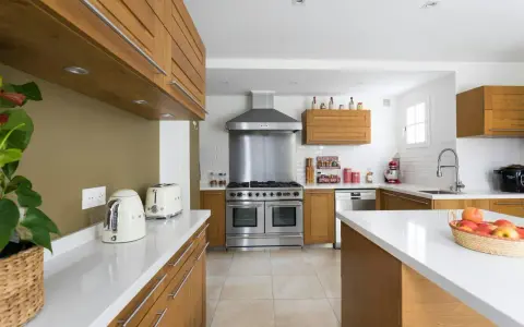 Cuisine moderne avec îlot central, électroménagers en inox et bois. Idéal pour estimer le prix rénovation maison m2.