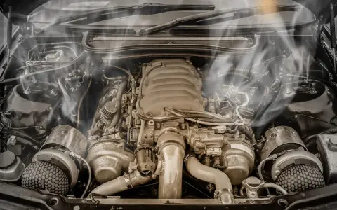 Smoke billows from a car's engine bay, indicating an engine overheating issue. The complex machinery sits idle, a testament to potential mechanical trouble.