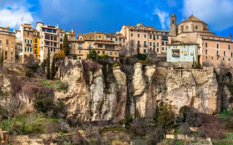 Häuser klammern sich an steile Felsen in Cuenca, Spanien. Eine Kathedrale thront über der Stadt.