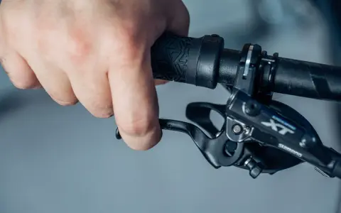 Hand betätigt den Bremshebel, um die hydraulische Scheibenbremse einzustellen.