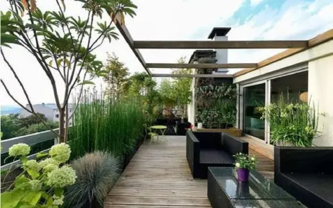 Un accogliente terrazzo rustico con mobili neri, un giardino verticale e piante rigogliose, ideale per rilassarsi.