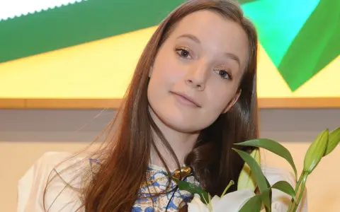 Sanah z bukietem białych lilii, uśmiechnięta, jakby przeżywała najlepszy dzień w moim życiu.