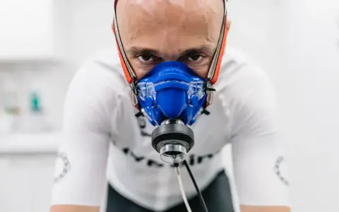 Mężczyzna w masce do testów wydolnościowych, badanie VO2 max. Intensywny wysiłek w celu poprawy kondycji.