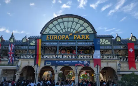 Einlass zum Europa-Park mit Fahnen und jubelnden Besuchern.