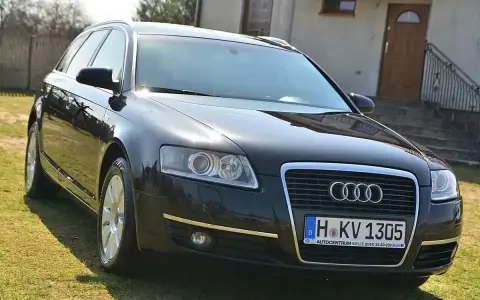 Czarny Audi A6 C6 3.0 TDI na trawie przed domem.