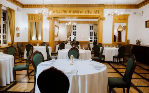 Elegancka sala bankietowa w lisewskim dworze, nakryte stoły czekają na gości.