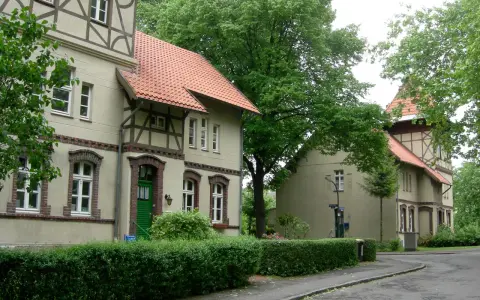 Fachwerkhäuser in der alten Kolonie Eving, umgeben von üppigem Grün und Bäumen.