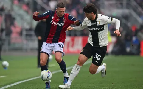 Piłkarze Bologna – Parma walczą o piłkę na boisku.