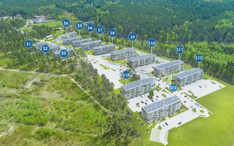 Widok z lotu ptaka na osiedle budynków mieszkalnych otoczone lasem, z oznaczeniami budynków.