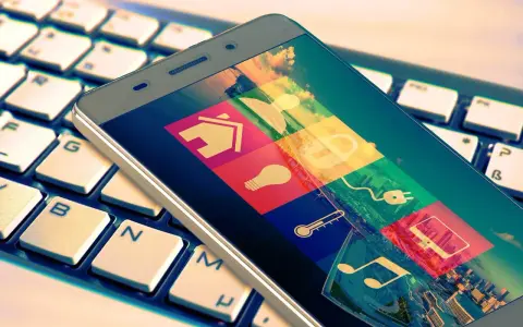 Smartphone mit Smart-Home-Symbolen auf Tastatur. Das Hacken Bedeutung wird hier durch die vielen Icons symbolisiert, die Zugang zu verschiedenen Bereichen des Lebens gewähren.