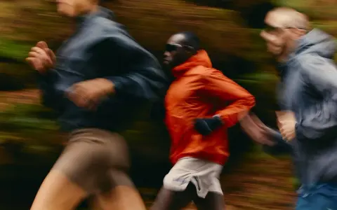 Trois coureurs en mouvement dans un décor forestier, suivant un programme reprise course à pied.