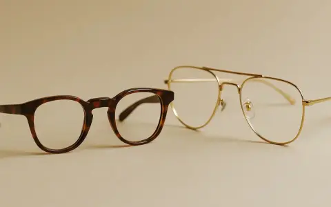 Dwa modele okularów: jeden w stylu retro, w ciemnej oprawce, drugi – złoty, pilotki. Wybór: okulary z noskami czy bez?