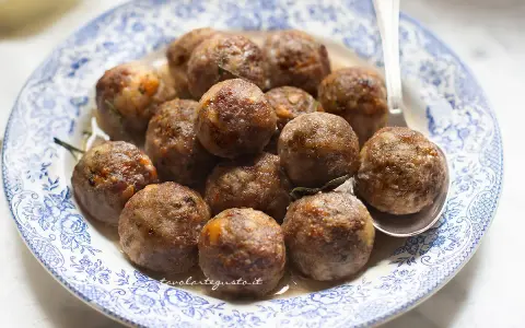 Polpette dorate e succulente in friggitrice ad aria, servite su un piatto con decori blu.