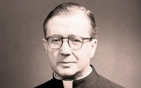 Portrait of a man in clerical attire, wearing glasses. His thoughtful gaze suggests an opus work of God, a life dedicated to faith and service.