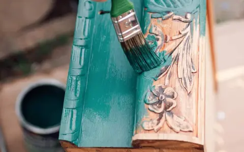 Pintura a la tiza verde turquesa cubriendo un marco de madera tallada.