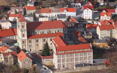 Widok z góry na miasteczko z czerwonymi dachami, w centrum imponujący kościół i zabudowania. To urokliwe bardo śląskie.