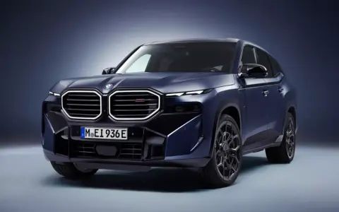 Mroczny, lśniący BMW XM w kolorze granatowym prezentuje swoją masywną sylwetkę i charakterystyczny grill.