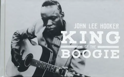 John Lee Hooker, King of the Boogie, spielt Gitarre. Sein Blick ist konzentriert, während seine Finger über die Saiten gleiten.