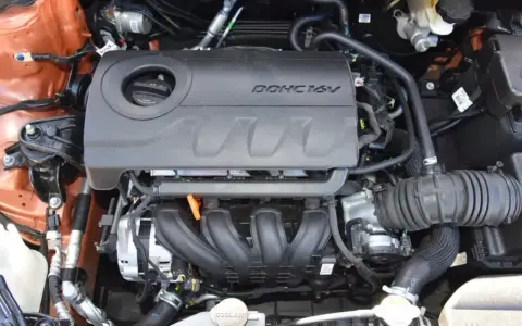 Silnik MPI DOHC 16V, widok z góry. Widać kolektor dolotowy, osłonę silnika i elementy układu dolotowego.