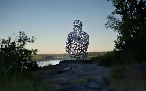 Skulptur av bokstäver vid Artipelag Stockholm, med en sjö i bakgrunden.