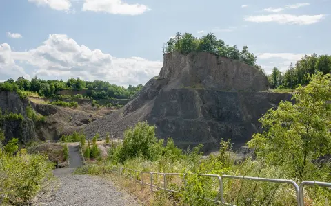 Kamieniołom przypomina wilczą górę, z której wyrasta bujna zieleń. Ścieżka prowadzi w głąb skalistego krajobrazu.