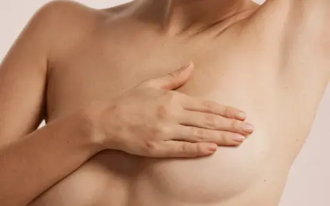 Dłoń na piersi, sugerująca delikatność i troskę. Możliwe, że to efekt masażu próżniowego biustu, który poprawia jego wygląd.