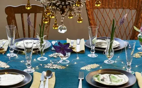 Une table dressée avec élégance, des verres étincelants et des fleurs délicates. L'art de la table est célébré sous un lustre scintillant.