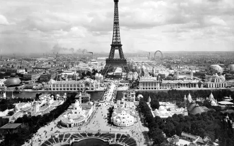 Vista panorámica del **Champ de Mars** con la Torre Eiffel dominando el paisaje, rodeada de pabellones y una noria.