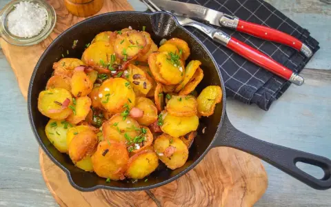 Goldbraune Bratkartoffeln mit Speck und Schnittlauch in der Pfanne. Perfekt als Beilage, denn dazu passt fast alles!