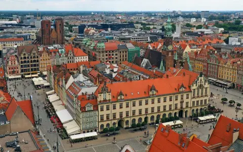 Widok z góry na kolorowy rynek z kamienicami, ratuszem i kościołem. To chyba najładniejszy rynek w Polsce, tętniący życiem.