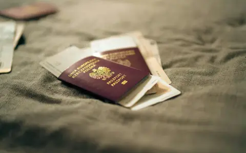 Kilka paszportów leży na szarym materiale. Zastanawiasz się, ile czeka się na paszport w Polsce?