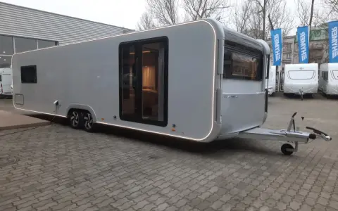 Nowy Adria Astella 904 HP, luksusowy caravan z panoramicznymi oknami i nowoczesnym designem, gotowy na podróże.