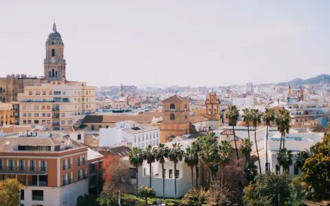 Widok na miasto z palmami i katedrą, idealne miejsce na lot Berlin-Malaga.