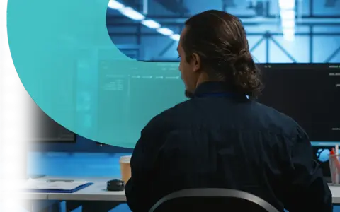 Analityk pracuje nad cyber threat intelligence, analizując dane na monitorach w serwerowni.