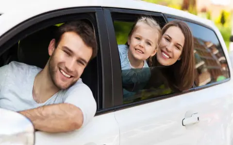 Famiglia felice in auto, un nuovo inizio dopo il passaggio di proprietà auto tra familiari.