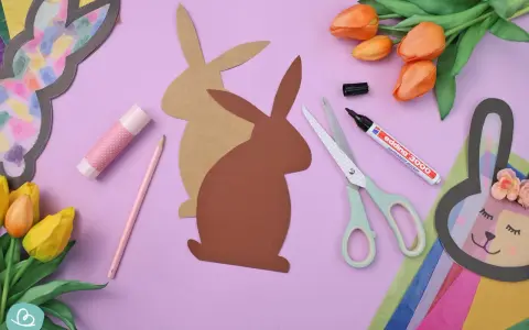 Bastelmaterialien für einen Osterhasen aus Tonpapier: Schere, Stift, Kleber, Tulpen und Hasen-Vorlagen.