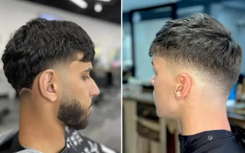 Zwei Männer mit stylischem taper cut. Der linke hat dunkles Haar und Bart, der rechte helleres Haar.