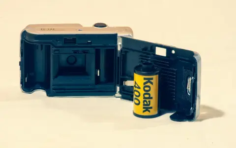 Otwarta klapka aparatu z włożonym rolką filmu Kodak 400. Klasyczny film analogowy gotowy do uchwycenia wspomnień.