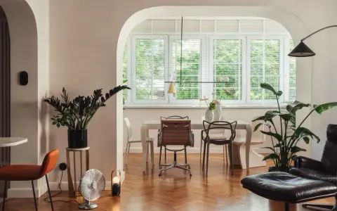 Eklektyczny salon z jadalnią, gdzie nowoczesne meble i rośliny tworzą przytulną atmosferę.