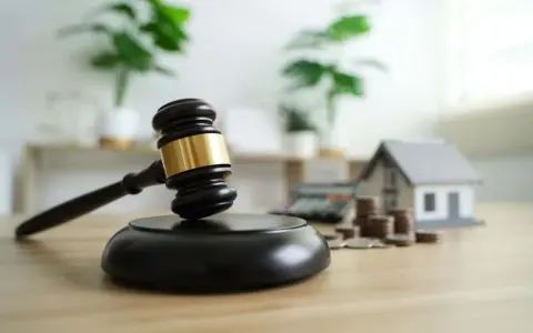 Marteau de juge, maison miniature, calculatrice et pièces. Le virement notaire combien de temps ?
