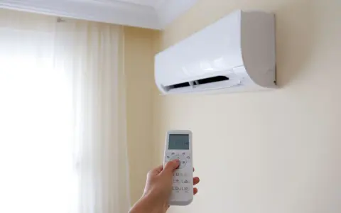 Mano che regola il climatizzatore per un ambiente fresco e dry.